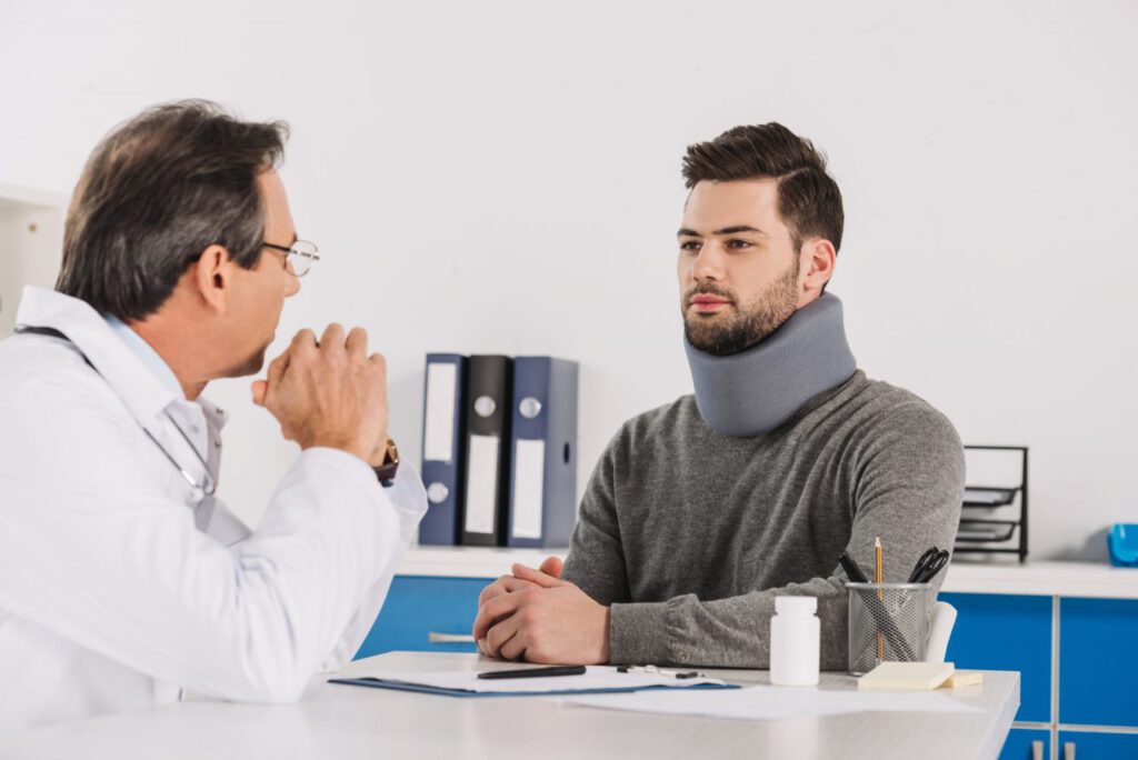doctor talking with patient in neck brace 2021 09 29 02 16 43 utc scaled e1639683631477