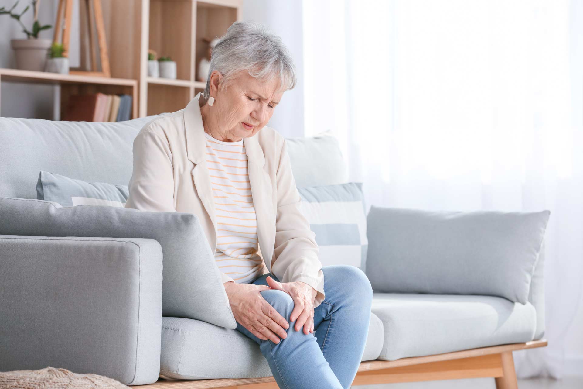 Older woman holding her knee due to knee pain